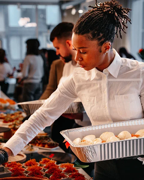Professional catering staff serving guests at a corporate event in Greater Montreal, ensuring a relaxed business atmosphere.
